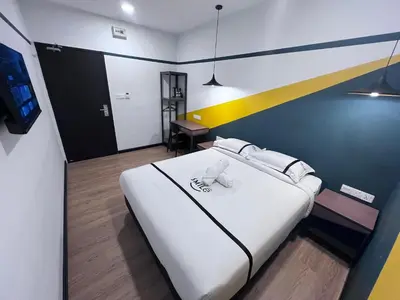 a large white bed in a room with a yellow stripe at Seeds Hotel PV12 in Kuala Lumpur