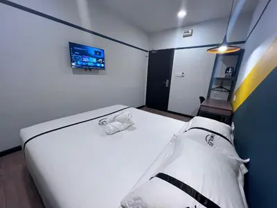 a bedroom with a large white bed and a tv at Seeds Hotel PV12 in Kuala Lumpur