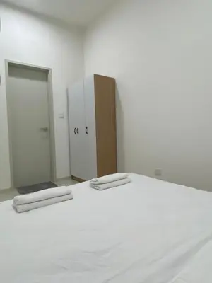 a white bedroom with a bed and a cabinet at MAJESTIC RESlDENCE KLCC in Kuala Lumpur