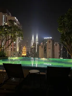 a swimming pool with a city skyline at night at MAJESTIC RESlDENCE KLCC in Kuala Lumpur