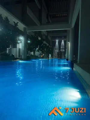 a swimming pool at night in a hotel at KLCC Cozy Suite 21F with Best View Infinity Pool in Kuala Lumpur