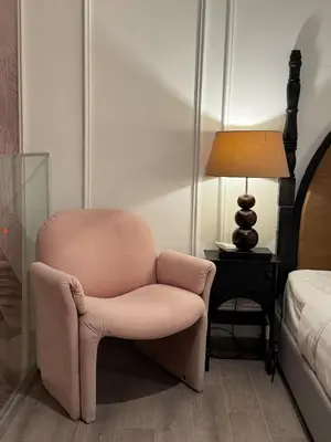 a pink chair sitting in a room next to a bed at Deluxe Duplex Studio Suite at Agile Bukit Bintang in Kuala Lumpur