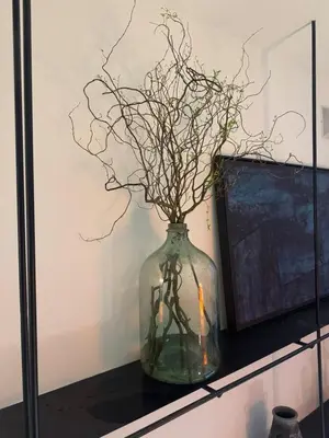 a glass vase with branches in it on a shelf at Deluxe Duplex Studio Suite at Agile Bukit Bintang in Kuala Lumpur