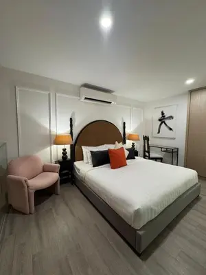 a bedroom with a large bed and a chair at Deluxe Duplex Studio Suite at Agile Bukit Bintang in Kuala Lumpur