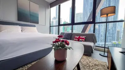 a bedroom with a bed and a table with flowers on it at Scarletz Suite KLCC By Light House 3 in Kuala Lumpur