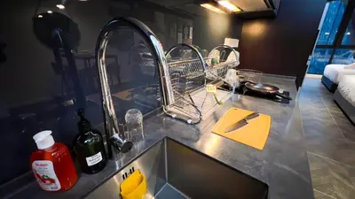 a kitchen counter with two sinks and detergents at Scarletz Suite KLCC By Light House 3 in Kuala Lumpur