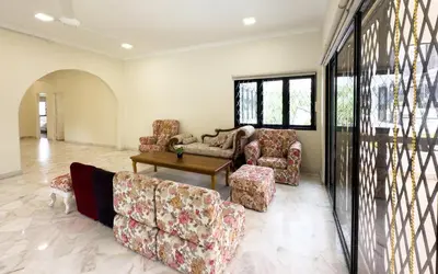 a living room with couches and a table and windows at Damansara Heights Luxury Villa with Private Pool in Kuala Lumpur