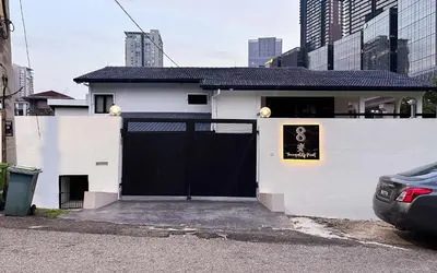 a white house with a black gate in a city at Damansara Heights Luxury Villa with Private Pool in Kuala Lumpur