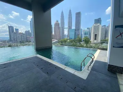 a swimming pool with a view of a city skyline at Cozy Stay at Legasi 5 minutes Walking distance to KLCC in Kuala Lumpur
