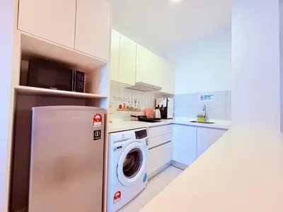a white kitchen with a washing machine in it at Chamber Luxury Serviced Suites KL in Kuala Lumpur