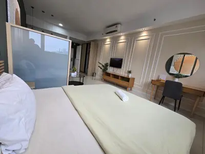 a bedroom with a white bed and a mirror at Chamber Luxury Serviced Suites KL in Kuala Lumpur