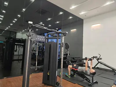 two people in a gym doing squats on a machine at GRAND Suites Chamber AT Klcc in Kuala Lumpur