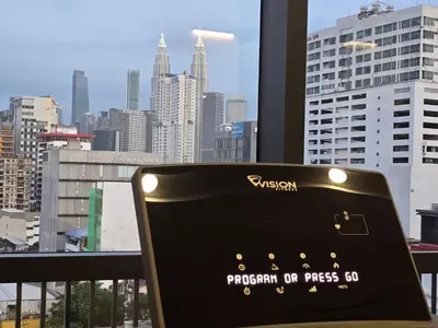 a chair in front of a window with a view of a city at GRAND Suites Chamber AT Klcc in Kuala Lumpur