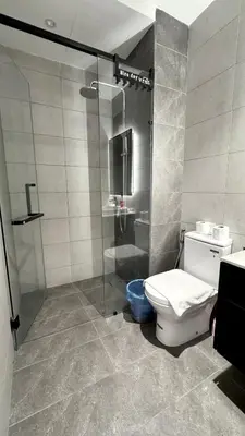 a bathroom with a toilet and a glass shower at Visitors Axon Residence Bukit Bintang KL City Center in Kuala Lumpur