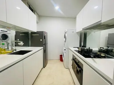 a kitchen with white cabinets and a black refrigerator at Votrex Suites KLCC By Classic Home in Kuala Lumpur