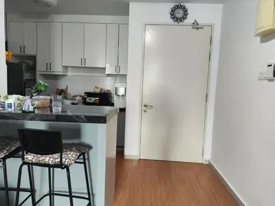 a kitchen with white cabinets and a counter with two bar stools at Legasi Kampong Bharu in Kuala Lumpur