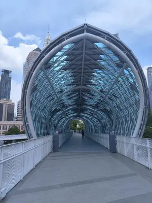 a bridge in a city with a person walking on it at Legasi Kampong Bharu in Kuala Lumpur