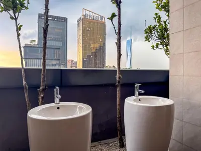 two urinals in a bathroom with a view of a city at TRX Pavilion Top Floor Suite, Kid-Friendly Slide, Dorsett Bukit Bintang KL, Kuala Lumpur Malaysia in Kuala Lumpur
