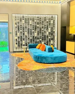 a living room with a blue couch in front of a wall at Majestic Residences KLCC By Cozy in Kuala Lumpur