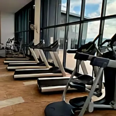 a row of exercise machines in a gym with windows at 3 Towers Urban Studio Apartment in Kuala Lumpur