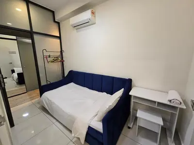 a small bedroom with a blue bed and a table at RuangWaktu at Arte Mont Kiara in Kuala Lumpur