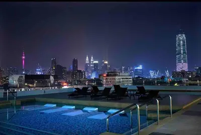 a swimming pool with a city skyline at night at Infinity Pool 7pax City Homestay KL Mrt Velo TRX in Kuala Lumpur