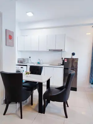 a kitchen with a table and two black chairs at Arte Plus by Stay Relax in Kuala Lumpur