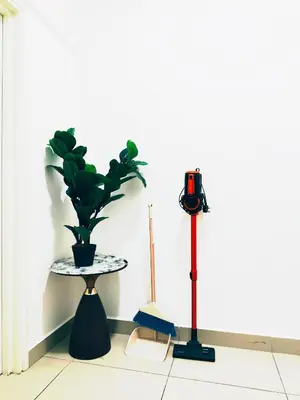 a table with a potted plant and a vacuum at Arte Plus by Stay Relax in Kuala Lumpur