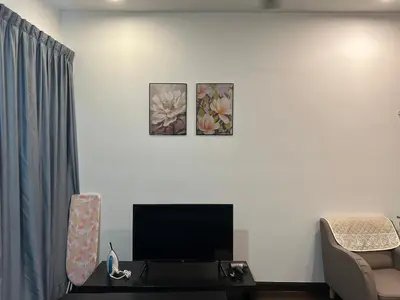 a living room with a flat screen tv on a white wall at V Residence Suites, Sunway Velocity by Rasbo Galaxy Suites in Kuala Lumpur