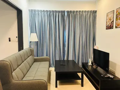 a living room with a couch and a television at V Residence Suites, Sunway Velocity by Rasbo Galaxy Suites in Kuala Lumpur