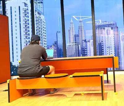 a person sitting on a bench looking out a window at a city at Kuala Lumpur Luxury Suites By Majestic Residence in Kuala Lumpur