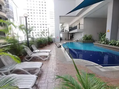 a hotel with a swimming pool and lounge chairs at Seri Bukit Ceylon apartment in Kuala Lumpur