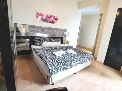 a bedroom with a black and white bed and a mirror at Seri Bukit Ceylon apartment in Kuala Lumpur