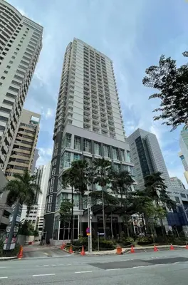 a tall building with palm trees in front of it at Seri Bukit Ceylon apartment in Kuala Lumpur