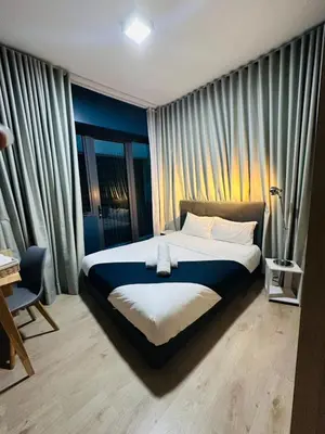 a bedroom with a large bed in front of curtains at The Colony By Infinitum With Klcc View in Kuala Lumpur