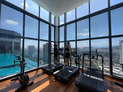 a group of people on treadmills in a gym with a view at Novo Suites Kuala Lumpur by Nestaway Jalan Ampang in Kuala Lumpur