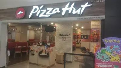 a pizza hut restaurant with a man in front of it at QUILL RESIDENCE by ASHNAS 3 in Kuala Lumpur