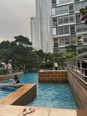 a person in a swimming pool in a city at KLCC Marc Residence by AZ Line in Kuala Lumpur