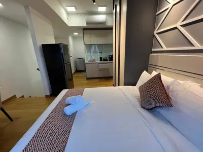 a bedroom with a large bed with a blue ribbon on it at The Colony By Infinitum KLCC - Aura Suites in Kuala Lumpur