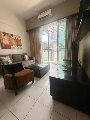 a living room with a couch and a table and a television at AL Seri Bukit Ceylon in Kuala Lumpur