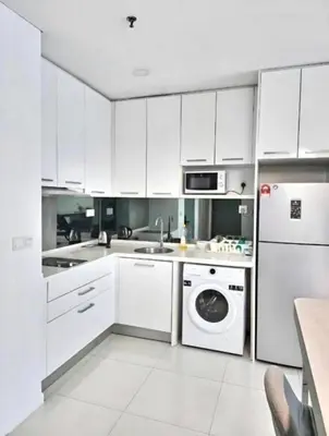 a kitchen with white cabinets and a washer and dryer at Studio Apartment KLCC Area in Kuala Lumpur