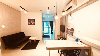 a living room with a black couch and a table at Studio Apartment KLCC Area in Kuala Lumpur