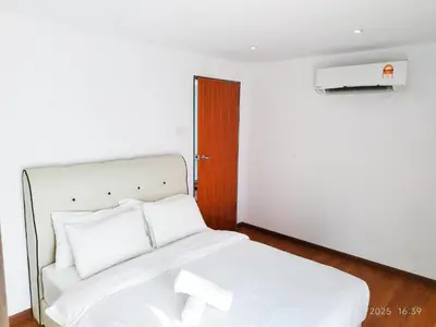 a white bed with white sheets and a wooden door at Arina Uniti Kampung Baru HKL - Idealhub in Kuala Lumpur
