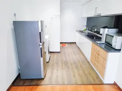 a kitchen with a refrigerator and a wooden floor at Arina Uniti Kampung Baru HKL - Idealhub in Kuala Lumpur