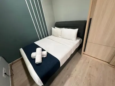 a small room with a bed with a cross on it at The Colony By Infinitum With Rooftop Pool in Kuala Lumpur