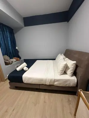 a bedroom with a bed with white sheets and pillows at The Colony By Infinitum With Rooftop Pool in Kuala Lumpur