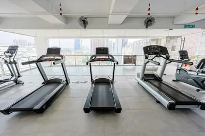 a gym with several treadmills and a large window at D'Majestic by Aspire Suites in Kuala Lumpur