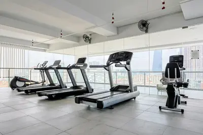 a gym with several tread machines in a building at D'Majestic by Aspire Suites in Kuala Lumpur