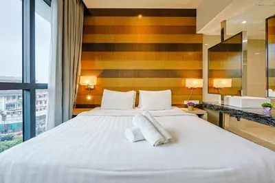a bedroom with a large bed and a large window at D'Majestic by Aspire Suites in Kuala Lumpur