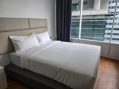 a bedroom with a white bed with a large window at Vortex suites klcc by KAZI in Kuala Lumpur